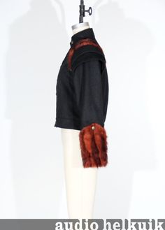 A great short jacket made out of a luxurious black wool fabric.  Fully lined with a rust/black vintage lining fabric.  Jacket features two sets of structured wings at shoulders.  It also has fur trim on shoulders and large fur cuffs. Jacket closes at center front with brass buttons.  It also has brass buttons details on the fur trim at shoulders and cuffs.Shown on a female dress form but looks great on any gender.  Size small.  Bust: 34-36" or Chest: 30-34" Black Wool Fabric, Fur Cuffs, Female Dress, Brass Buttons, Dress Form, Black Vintage, Short Jacket, Wool Fabric, Lining Fabric