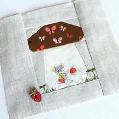 a close up of a piece of cloth on a table with a mouse and strawberry