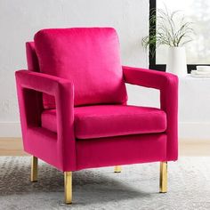 a bright pink chair sits in front of a white wall with a potted plant