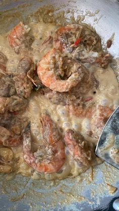 shrimp and grits are being cooked in a skillet