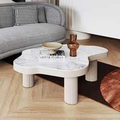 a white marble coffee table in front of a gray couch