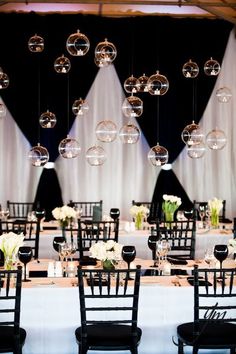 the tables are set with black and white linens, silverware, and flowers