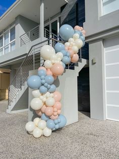 a bunch of balloons that are on the side of a building in front of some stairs