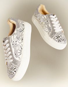 Put a little sparkle in your step with the REILY rhinestone sneakers. This sneaker can be paired with your best dress or favorite jean! Its intricate pattern is an eye-catching way to make a statement, no matter where you're wearing it. Manmade rhinestone platform sneakers Lace up closure Textile lining Rubber sole 1.5 inch platform Imported Spring Bling Sneakers With Round Toe, Trendy Rhinestone Sneakers For Spring, White Low-top Sneakers For Party, Silver Bedazzled Low-top Sneakers, White Rhinestone Round Toe Sneakers, Embellished Lace-up Sneakers For Spring, White Embellished Lace-up Sneakers, Spring Embellished Lace-up Sneakers, Trendy Bling Lace-up Sneakers