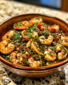 a wooden bowl filled with shrimp and vegetables on top of a marble countertop next to a bottle of wine