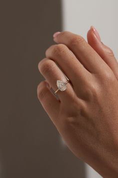 a woman's hand with a diamond ring on it