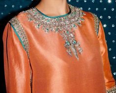 Product Description:  Gorgeous outfit with a shalwar and shorts made of raw silk. Silver Mukesh work, silver naqshi, silver sequins, teal green sequin, silver dabka, and pink buggle beads are used to adorn the shirt's neckline and borders. This outfit looks outstanding thanks to the shalwar's charming border, same-kind embroidery, and embellishments.  Color: Orange Can be customized in any color Includes:  Shirt Pants Duppata Silk Kurta With Sequins For Festivals, Silver Hand Embellished Sharara For Festive Occasions, Festive Silver Hand Embellished Sharara, Eid Silver Raw Silk Set, Silver Designer Salwar Kameez For Eid, Festive Hand Embellished Silver Sharara, Festive Silver Hand-embellished Sharara, Silver Kurta With Resham Embroidery For Party, Party Silver Kurta With Resham Embroidery