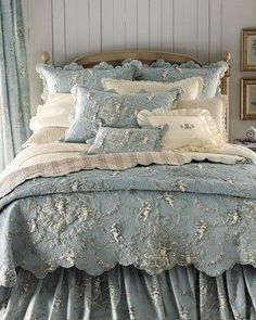 the bed is made with blue and white comforters