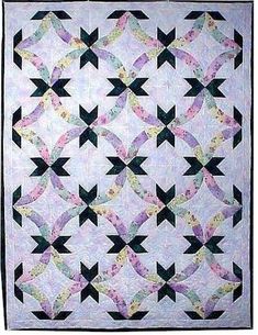 a white quilt with black and pink designs on the front, along with two different colors