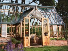 a wooden greenhouse with glass walls and windows