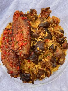 a plate with meat, rice and vegetables in it on a white tablecloth background