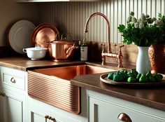 copper pots and pans are sitting on the kitchen counter