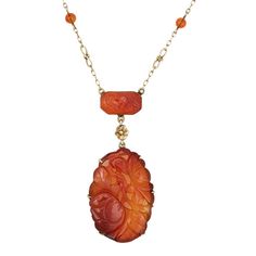 Finely detailed vintage Art Deco era carved carnelian necklace (circa 1920s to 1930s), crafted in 14 karat yellow gold.    The larger carnelian drop measures 1 1/2 x 1 inch, with the smaller rectangular piece measuring 15mm x 9mm. Small 4.5mm beads are set into the chain. The carnelian is in very good condition and free of cracks or chips.    Carnelian is carved in a floral and botanical motif, set into a beautiful ornate infinity link chain. The necklace is great worn as a statement piece or layered with your fine jewelry from any era.    The necklace is in very good original condition and was lightly cleaned and polished.    Particulars:    Weight: 14 grams    Stones: The larger carnelian drop measures 1 1/2 x 1 inch, with the smaller rectangular piece measuring 15mm x 9mm. Small 4.5mm b Antique Carved Carnelian Jewelry, Vintage Carved Carnelian Jewelry, Carved Carnelian Vintage Jewelry, Antique Carved Yellow Gold Necklaces, Elegant Engraved Carnelian Jewelry, Formal Carnelian Cameo Jewelry, Formal Cameo Jewelry In Carnelian, Formal Cameo Carnelian Jewelry, Elegant Carved Orange Jewelry