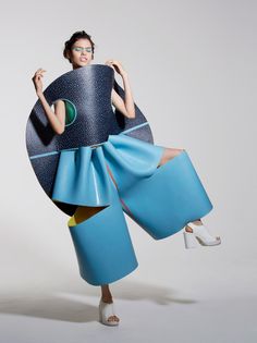 a woman in a blue dress is holding a large object