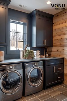 a washer and dryer in a room with wood walls on the back wall