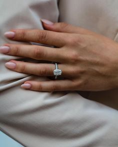 a close up of a person's hand with a diamond ring on their finger