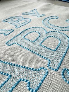 a close up view of a blue and white table cloth with an embroidered design on it