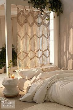 an unmade bed with white sheets and pillows in a room next to a window