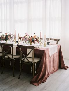 the wedding table is set with flowers and candles