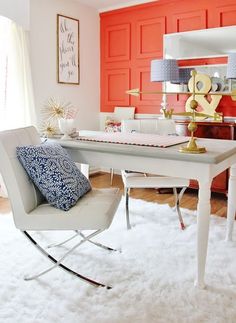 a white desk and chair in a room with red paneled walls on the wall