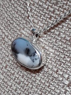 One of a kind, handcrafted, Dendritic Opal and sterling silver pendant.  Measures about 21mm X 19mm.  CHAIN NOT INCLUDED. Handmade Sterling Silver Memorial Necklace, Handmade Sterling Silver Necklace For Memorial, Spiritual Silver Necklace With Natural Inclusions, White Round Necklace For Memorial, White Round Necklaces For Memorial, White Memorial Necklace, Unique Sterling Silver Necklace For Memorial, White Pendant Necklace For Memorial, White Cabochon Sterling Silver Necklace