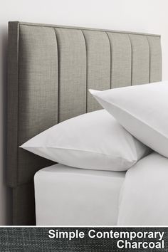 a close up of a bed with white sheets and pillows