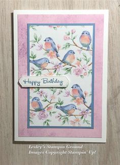 a happy birthday card with two birds on a tree branch and flowers in the background