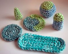 crocheted objects are displayed on a white surface with blue and green yarns