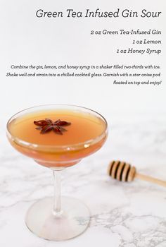 a cocktail in a coupe glass next to a honey comb on a marble counter top