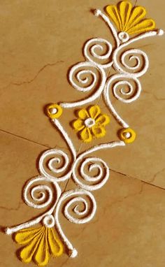 a yellow and white design on the ground with some flowers painted on it's side