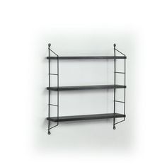 three black shelves on the wall with one shelf hanging off it's side, and two