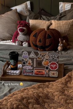 two stuffed animals sitting on top of a bed next to a tray with stickers