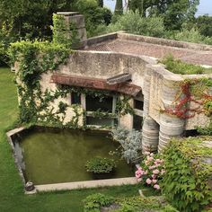 an aerial view of a building with water in the middle and lots of greenery around it