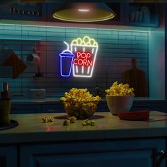 a neon sign that says popcorn and a bowl of popcorn sits on a kitchen counter