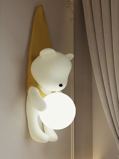 a lamp that is on the side of a wall next to a teddy bear sculpture