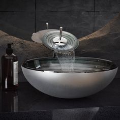 a bowl shaped sink with water running from the faucet