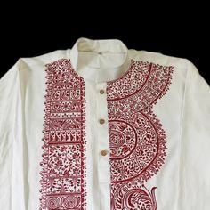 a white shirt with red designs on it