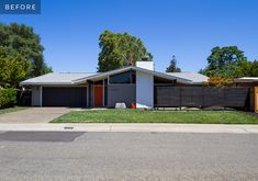 a house that is sitting on the side of a road with grass in front of it