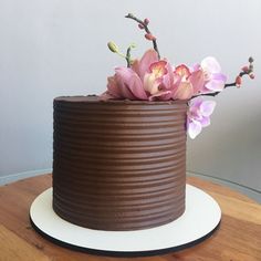 a chocolate cake with pink flowers on top