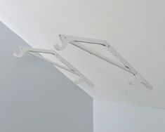 two white clothes hangers attached to the ceiling