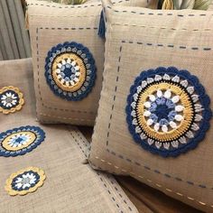 three decorative pillows with crocheted designs on them