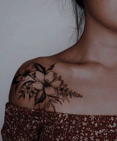 a woman's shoulder with flowers on it, and the bottom half of her arm