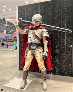 a man dressed in costume holding a baseball bat next to a wall with writing on it