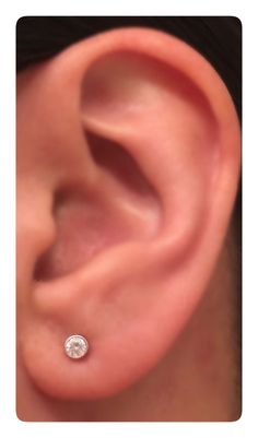 an ear with a single diamond in it