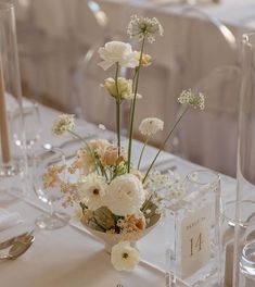 the table is set with flowers and place cards for guests to sit down at it