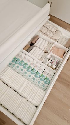 an open drawer filled with lots of toiletries on top of a hard wood floor