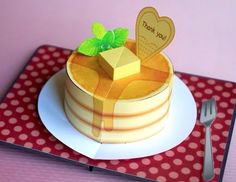 there is a cake on the table with a heart shaped card and fork next to it