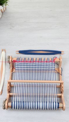 an old weaving machine with blue and white striped fabric