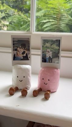 two marshmallows sitting next to each other on top of a window sill