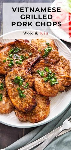 a white plate topped with fried pork chops and garnished with parsley